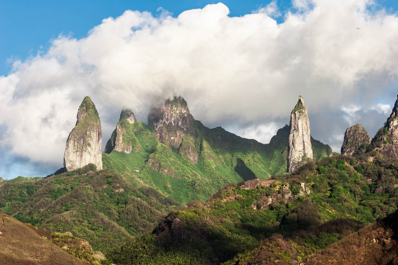 Clouds drift over the dramatic stone spires of Ua Pou Island in the Marquesas, French Polynesia.